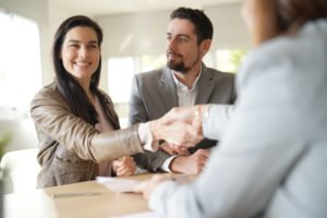 A couple shaking hands with a professional