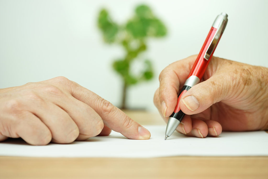 elder man signing agreement with lawyer