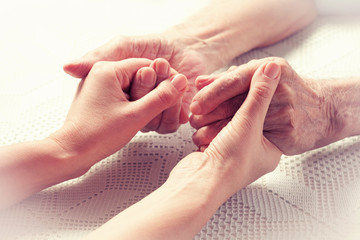 elderly care- hands of a care giver and an elder